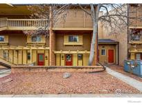 Inviting multi-story condo with red doors, brick accents, and a charming, tree-lined entrance at 3000 Colorado Ave # 124, Boulder, CO 80303