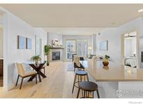 Bright, open-concept living space features modern decor, a fireplace, and access to a balcony with natural light at 3401 Arapahoe Ave # 315, Boulder, CO 80303