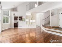 Bright living room features hardwood floors, an open layout, and easy access to the kitchen and upper level at 4808 Hopkins Pl, Boulder, CO 80301
