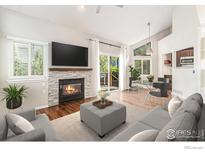 Bright living room with a fireplace, wood floors, neutral color palette, and access to a patio through glass sliding doors at 4808 Hopkins Pl, Boulder, CO 80301