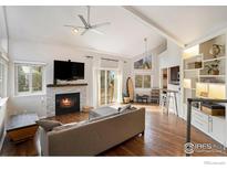 Bright living room featuring a fireplace, hardwood floors, and natural light from sliding glass doors at 4808 Hopkins Pl, Boulder, CO 80301