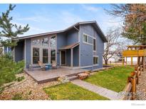Charming two-story home with a spacious front patio, lush lawn, and mature landscaping at 1095 Tantra Park Cir, Boulder, CO 80305