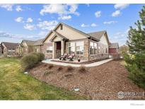 Charming home featuring a stone and siding exterior, front porch seating, and well-maintained landscaping at 12564 Madison Way, Thornton, CO 80241