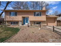 Charming two-story home featuring a well-maintained front yard and inviting blue front door at 1529 Ashcroft Dr, Longmont, CO 80501