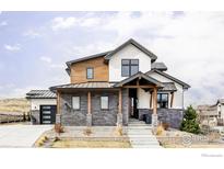 Charming two-story home boasts a stylish facade with mixed materials and a welcoming front porch at 15373 Irving Ct, Broomfield, CO 80023