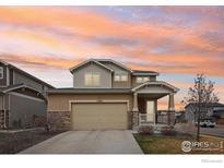 Beautiful two-story home featuring stone accents, a covered porch, and a two-car garage at 17995 E 107Th Pl, Commerce City, CO 80022