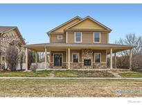 Charming two-story home featuring a spacious covered porch and stone fireplace at 2339 Whistler Dr, Longmont, CO 80504