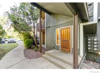 Inviting two-story home featuring a wooden front door, neutral colors, and a sidewalk leading to the street at 2865 Sundown Ln # 108, Boulder, CO 80303