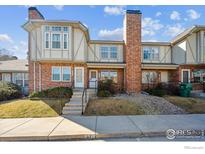 Traditional brick townhome featuring a tall chimney and well-maintained landscaping at 3006 W 107Th Pl # D, Westminster, CO 80031