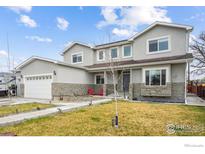 Beautiful two-story home with a well-manicured front lawn and stone accents at 3165 W 63Rd Ave, Denver, CO 80221