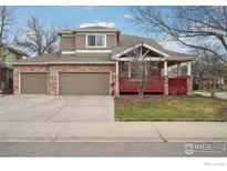 Charming two-story home with a brick facade, covered porch, and well-manicured lawn at 3940 Montclair Ln, Boulder, CO 80301