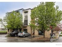 Modern condo building with brick facade, upper balconies, lush trees, and street parking at 4645 Broadway St # 1, Boulder, CO 80304