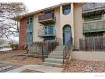 Multi-level condo building featuring balconies and a front entrance with stone steps and an address sign at 12180 Melody Dr # 203, Westminster, CO 80234