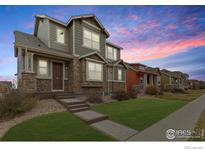 Charming two-story home with stone accents, a well-manicured lawn, and a welcoming entrance at 1513 Chokeberry St, Berthoud, CO 80513