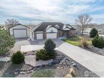Beautiful single Gathering home featuring a three-car garage, extended driveway, and meticulous landscaping at 16620 Umpire St, Hudson, CO 80642