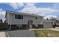 Charming two-story home featuring a brick facade, light gray paint, complemented by a well-maintained front yard at 2252 Smith Dr, Longmont, CO 80501