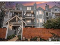 Gray townhome complex with brick facade, stairs, and balconies against a colorful evening sky at 2254 Spruce St # A, Boulder, CO 80302