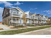 Charming row of townhomes featuring private balconies, fenced front yards, and colorful exteriors at 2754 Bear Springs Cir, Longmont, CO 80503
