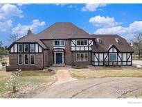 Charming two-story home with a blue door, brick accents, and well-maintained landscaping at 28800 E 168Th Ave, Brighton, CO 80603