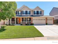 Charming two-story home boasts a well-manicured lawn, a spacious three-car garage, and inviting front porch at 3050 N Torreys Peak Dr, Superior, CO 80027