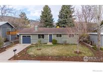 Charming single-story home with a well-manicured lawn, mature trees, and an attached single car garage at 3545 Cloverleaf Dr, Boulder, CO 80304