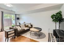 Bright living room featuring hardwood floors, a modern sofa, a stylish coffee table, and sliding glass doors to the outside at 3790 Iris Ave # B, Boulder, CO 80301
