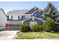 Charming two-story home with a well-manicured lawn and beautiful landscaping at 5001 Bella Vista Dr, Longmont, CO 80503