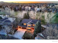Stunning two-story home with a well-manicured lawn, mature trees, and a three-car garage at 567 Manorwood Ln, Louisville, CO 80027