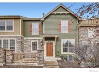 Inviting two-story townhome with stone accents, wooden shutters, a charming front porch, and an address number of 821 at 821 Stony Mesa Pl, Castle Rock, CO 80108