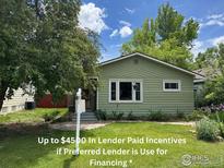 Charming home with a well-maintained lawn and inviting curb appeal, showcasing its classic design and green exterior at 117 Welch Ave, Berthoud, CO 80513