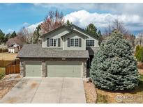 Inviting two-story home featuring an attached three-car garage, stone accents, and mature landscaping at 1508 Aspenwood Ln, Longmont, CO 80504