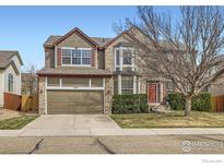 Charming two-story home featuring a brick and wood exterior with an attached two-car garage and well-maintained landscaping at 1534 Chukar Dr, Longmont, CO 80504