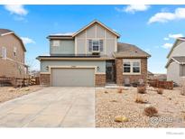 Charming two-story home featuring a blend of stone and siding, complemented by a well-maintained front yard at 17949 W 94Th Dr, Arvada, CO 80007