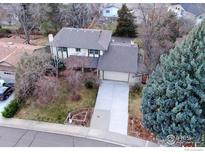 Aerial view of a two-story home with a long driveway, mature trees, and a well-maintained lawn at 21 Vassar Ct, Longmont, CO 80503