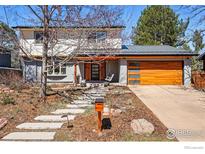 Charming two-story home with a modern garage door and inviting front porch swing at 3495 Endicott Dr, Boulder, CO 80305