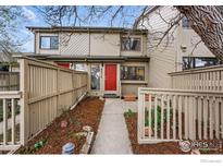 Charming townhome featuring a red front door, a fenced-in front yard and well-maintained landscaping at 4015 Wonderland Hill Ave, Boulder, CO 80304