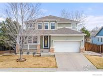 Inviting two-story home featuring a charming front porch and well-maintained landscaping at 4221 Pioneer Pl, Brighton, CO 80601