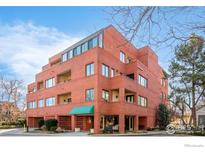 Modern red brick condo building with balconies and a green awning above the entrance at 624 Pearl St, Boulder, CO 80302