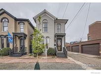 Charming two-story home featuring grey painted brick, well maintained front yard, and inviting entryway at 718 25Th St, Denver, CO 80205