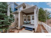 Inviting front porch featuring two chairs, fresh paint and charming architectural details at 737 Snowberry St, Longmont, CO 80503