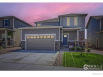 Charming two-story home with a gray exterior, well-kept lawn, and a two-car garage at 786 Griffith St, Lochbuie, CO 80603