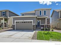 Charming two-story home with a gray exterior, well-kept lawn, and a two-car garage at 786 Griffith St, Lochbuie, CO 80603