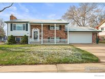Charming two-story home with brick and white siding, covered porch, and manicured lawn at 10805 Verna Ln, Northglenn, CO 80234