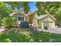 Charming two-story home with lush front yard, garden beds, and mature trees creating a welcoming curb appeal at 1117 Barberry Ct, Boulder, CO 80305