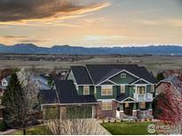 Charming two-story home with a spacious three-car garage and mountain views at sunset at 1348 Lawson Ave, Erie, CO 80516