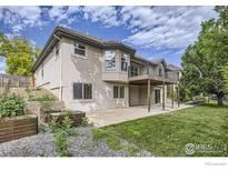 Spacious backyard with patio, deck, garden beds, and mature trees at 1730 Crestone Dr, Longmont, CO 80504