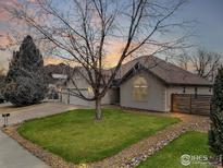 Charming single-story home with well-manicured lawn, beautiful landscaping, and a spacious three-car garage at 1730 Crestone Dr, Longmont, CO 80504