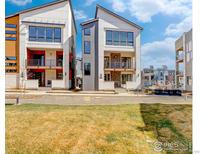 Modern townhomes with contemporary design, balconies, and landscaped front yard at 1778 Peak Loop, Broomfield, CO 80023