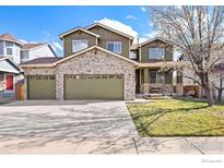 Charming two-story home with stone accents, three-car garage, and well-manicured lawn at 1788 Alpine Dr, Erie, CO 80516