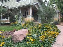 Charming home with beautiful flower garden, lush greenery, and rock landscaping at 3265 6Th St, Boulder, CO 80304